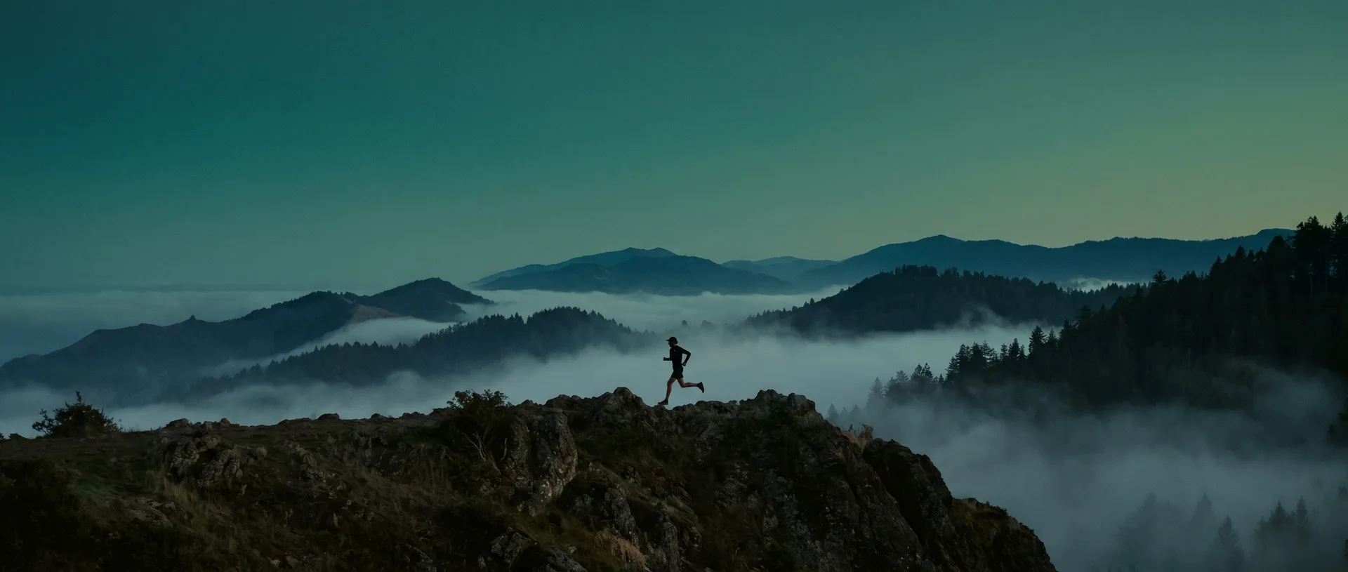 Trail runner on a mountain ridge at dusk